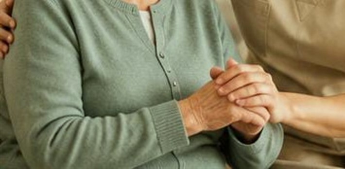 Mãos entrelaçadas entre cuidadora e paciente